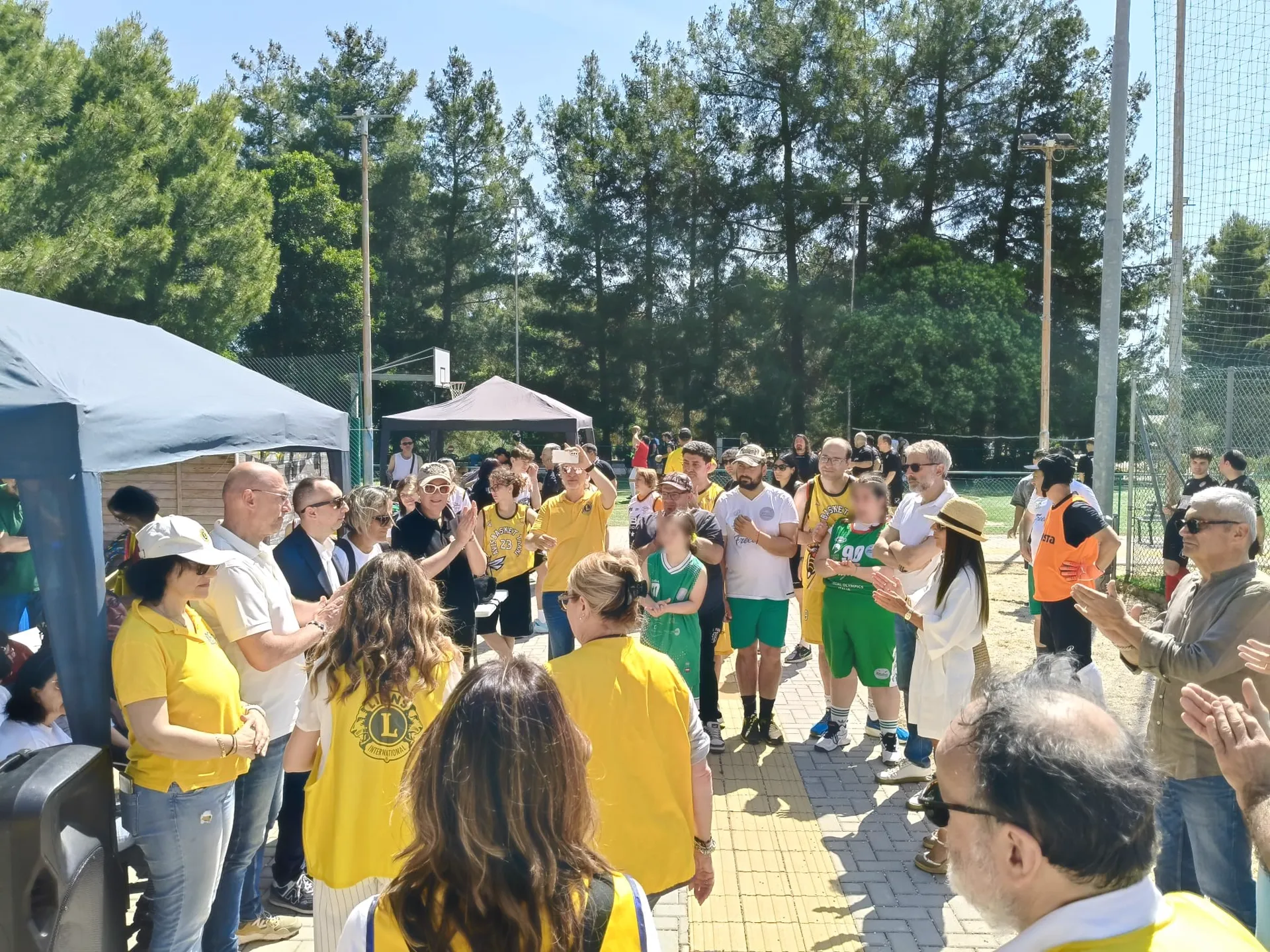 Applausi durante la Festa della Solidarietà: volontari in pettorina e atleti riuniti su un campo sportivo